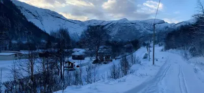 a snow covered mountain with houses and a ski lift at Storevatn Fritid in Masfjorden