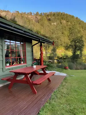 a picnic table on a deck in front of a house at Storevatn Fritid in Masfjorden
