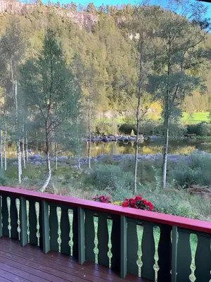 a balcony with a view of a river and trees at Storevatn Fritid in Masfjorden