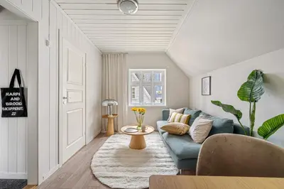 a living room with a blue couch and a table at Charming apt in the centre of Bergen in Bergen