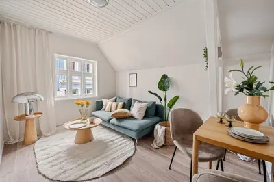 a living room with a blue couch and a table at Charming apt in the centre of Bergen in Bergen