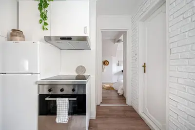a kitchen with a stove and a white wall at Charming apt in the centre of Bergen in Bergen
