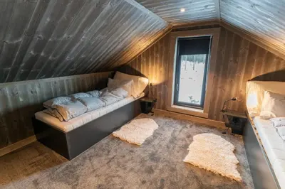 an attic room with a couch and a window at Luxury holiday home, skiing, sauna, remote office in Nesbyen
