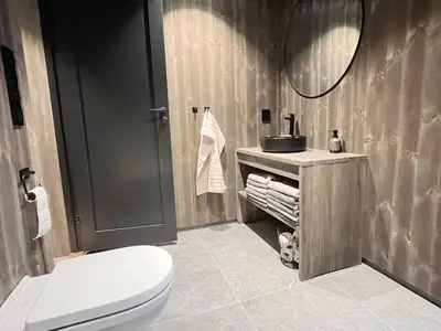 a bathroom with a toilet and a sink and a mirror at Luxury holiday home, skiing, sauna, remote office in Nesbyen