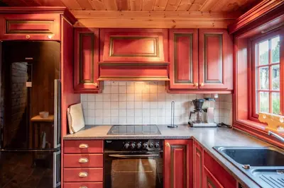 a kitchen with red cabinets and a stove at Lisetra 716A in Trysil