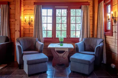 a room with two chairs and a table and windows at Lisetra 716A in Trysil