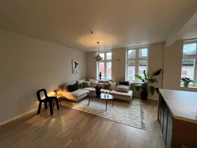 a living room with a couch and a table at Stay centrally in a charming and peaceful neighborhood in Bergen