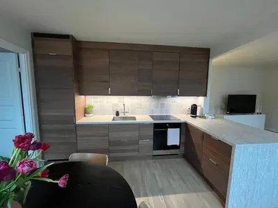 a kitchen with wooden cabinets and a sink and a table at Stay centrally in a charming and peaceful neighborhood in Bergen