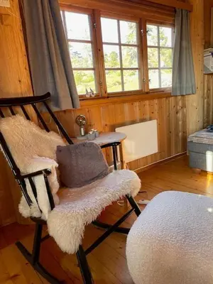 a room with a chair and a table and windows at Family Cabin At Birkebeiner Slopes In Sjusjøen in Sjusjøen