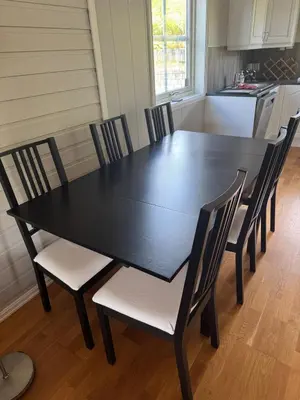 a black dining room table and chairs in a kitchen at 75 sqm with terrace and garden in Elverum