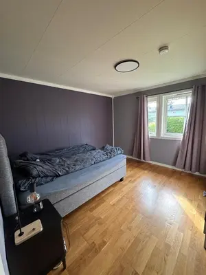 a bedroom with a bed and a window at 75 sqm with terrace and garden in Elverum