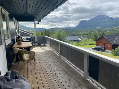 a balcony with a table and a view of mountains at Family house in Hemsedal in Hemsedal