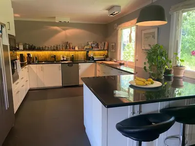a kitchen with white cabinets and a black counter top at Family house in Hemsedal in Hemsedal