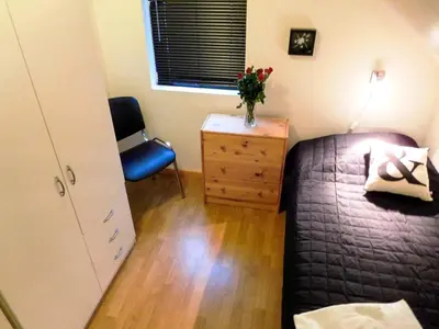 a bedroom with a bed and a chair and a dresser at 6 person holiday home in Sørbøvåg in Sørbø