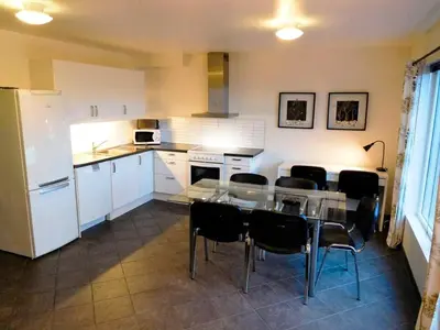 a kitchen with a table and black chairs in it at 6 person holiday home in Sørbøvåg in Sørbø