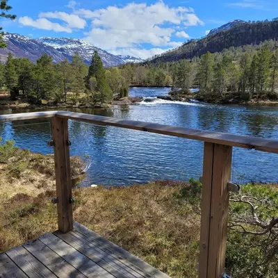 a view of a river from a wooden deck at Hytte ved Gaularfjellet in Viksdalen