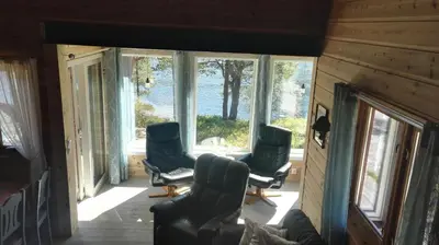 a living room with two chairs and windows at Hytte ved Gaularfjellet in Viksdalen
