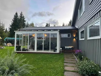 a screened in porch on the side of a house at Sentral familievennlig enebolig in Åmot