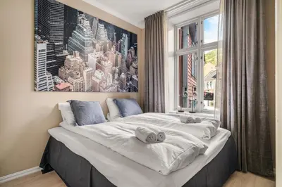 two beds in a bedroom with a large window at Bergen Beds Apartments - A Front Row Experience in Bergen