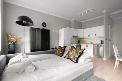 a living room with a white couch and a kitchen at Bergen Beds Apartments - A Front Row Experience in Bergen