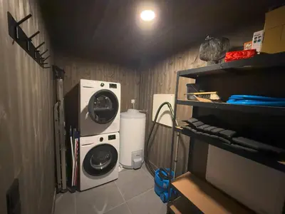 a laundry room with a washing machine and a washer at Ski centre, sauna, hot tub