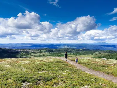 a woman and child walking down a path on a hill at Ski centre, sauna, hot tub