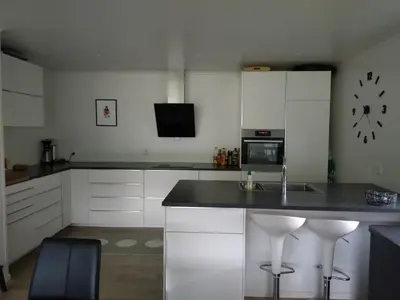 a kitchen with white cabinets and a black counter top at Koselig hus med flott utsikt in Vossevangen