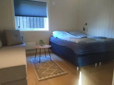 a living room with a bed and a table at Koselig hus med flott utsikt in Vossevangen
