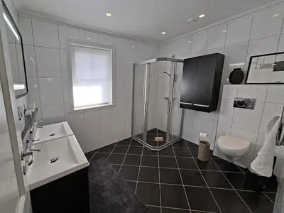 a bathroom with a shower and a toilet and a sink at Villa with lake view in Lunde