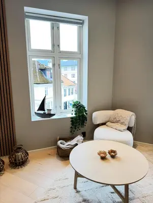 a living room with a table and a chair and a window at Bergen city centre, fantastic, new apartment in Bergen