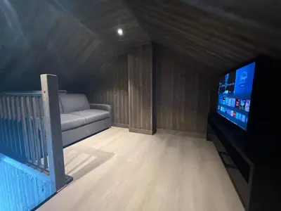 a living room with a couch and a flat screen tv at Robelia - Sauna, Hot tub - Norefjell ski center in Noresund