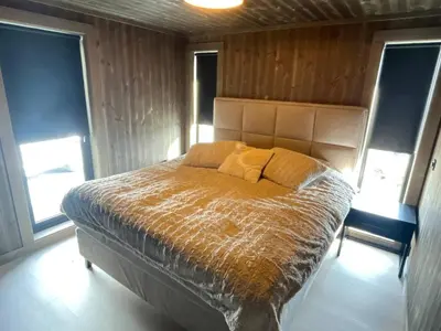 a bedroom with a bed in a room with windows at Robelia - Sauna, Hot tub - Norefjell ski center in Noresund