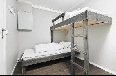 a bunk bed in a room with a ladder at Mountain apartment Norefjell Ski in ski out in Surteberg