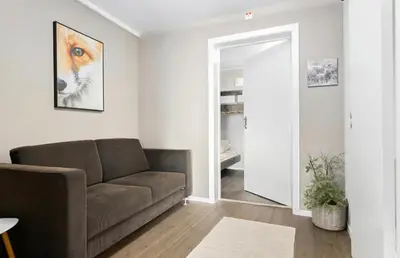 a living room with a brown couch and a mirror at Mountain apartment Norefjell Ski in ski out in Surteberg