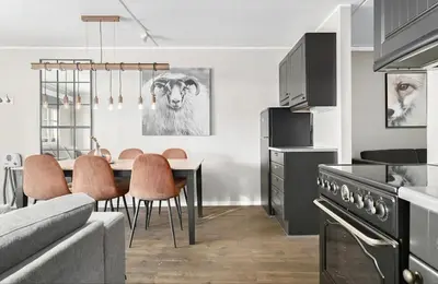 a kitchen and dining room with a table with a cow on the wall at Mountain apartment Norefjell Ski in ski out in Surteberg