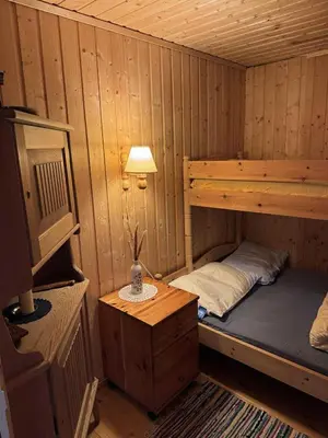 a small room with a bunk bed in a cabin at Cozy lakeside cabin in Trøndelag