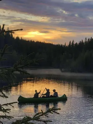 a group of three people in a canoe on a lake at Cozy lakeside cabin in Trøndelag