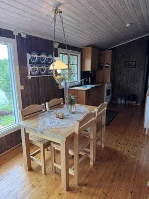 a kitchen with a table and chairs in a room at Cozy lakeside cabin in Trøndelag