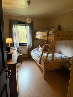 a bedroom with a bunk bed and a desk at Fossen bratte chalet in Eikedalen