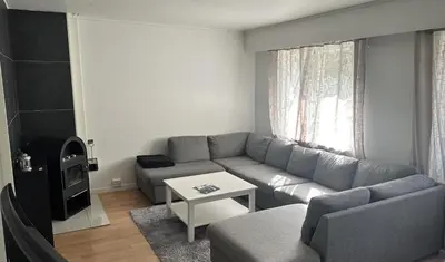 a living room with a couch and a table at Koselig 3 roms leilighet på Rjukan in Øverland