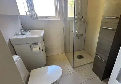 a bathroom with a shower and a toilet and a sink at Koselig 3 roms leilighet på Rjukan in Øverland
