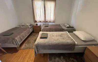 a room with two beds and a window at Koselig 3 roms leilighet på Rjukan in Øverland