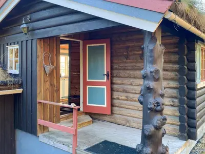 a log cabin with a red door and a porch at 6 person holiday home in LEKSVIK in Leksvik