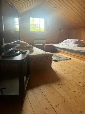 a room with two beds and a desk with a mirror at Cosy Family Cabin With Views And Sauna in Svingvoll