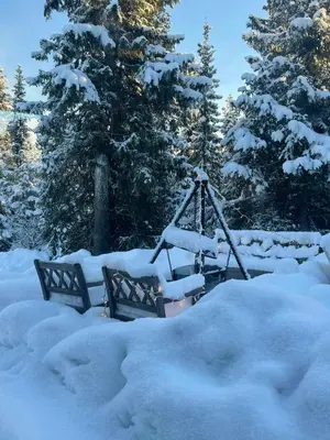 a swing in a yard covered in snow at Cosy Family Cabin With Views And Sauna in Svingvoll