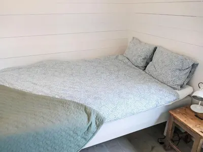 a bed in a small room with a wooden table at Holiday Home Lauvlid Cottage by Interhome in Tysnes