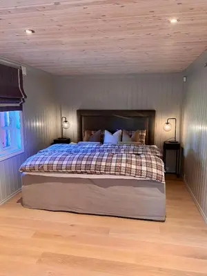 a bedroom with a large bed with a wooden ceiling at Bjarnebu - 4 bedroom cabin in Rauland in Rauland