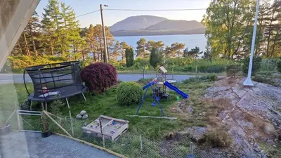 a backyard with a playground with a view of the water at Apartment in peacefull surroundings in Ådnavik