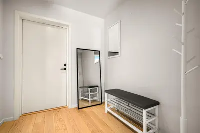 a white room with a bench and a mirror at Downtown Modern Apartment - Two Bedrooms! in Bergen