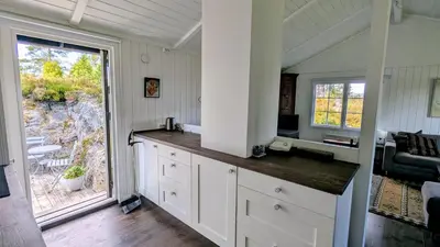 a kitchen with white cabinets and a large window at Soltoppen - cozy 3 bedroom cabin close to Norefjell